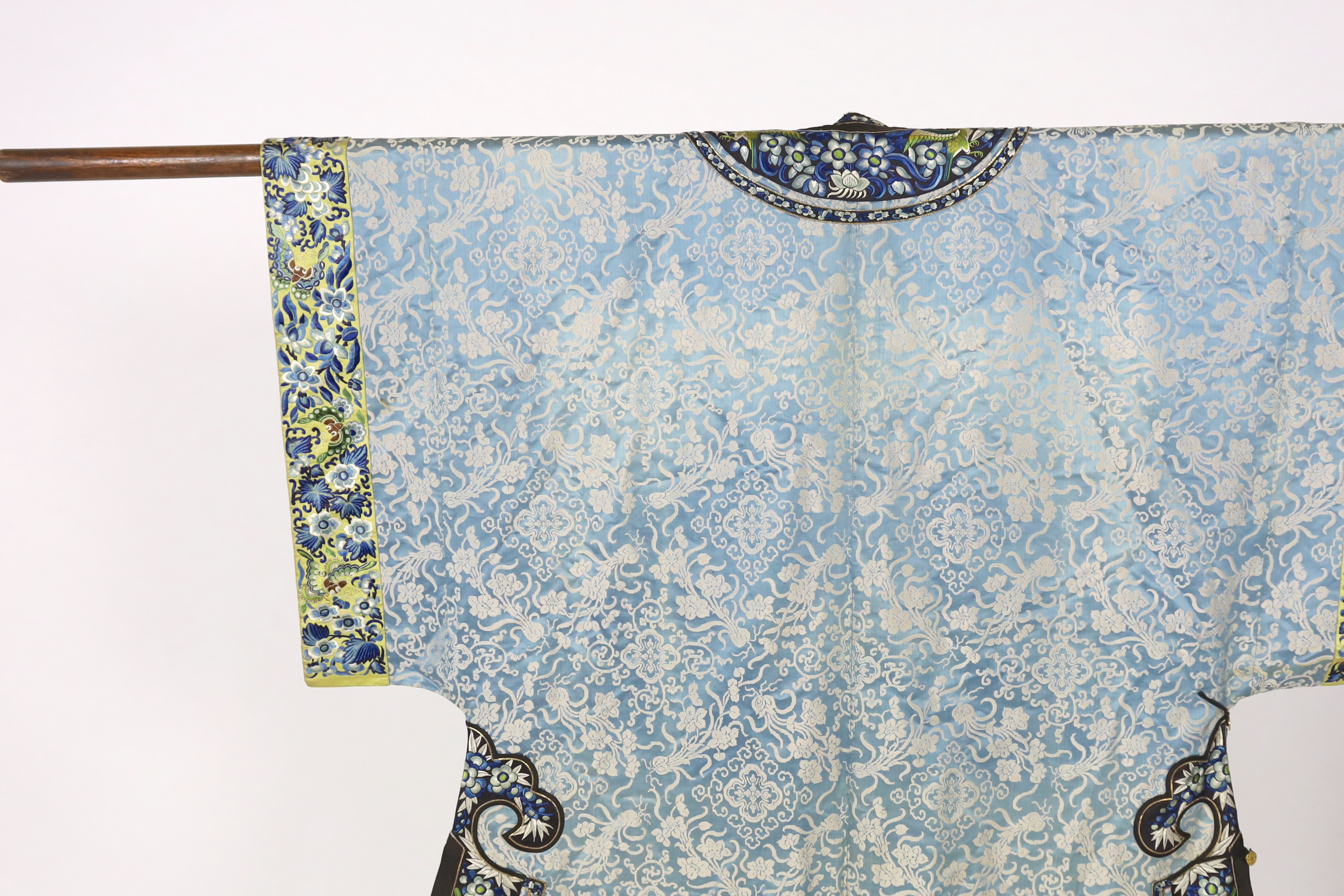 A late 19th / early 20th century silk damask robe, edged with highly ornate embroidered silk braiding, edged with fine gold and black borders, with yellow silk embroidered sleeve bands, the blue silk lining is faded in p